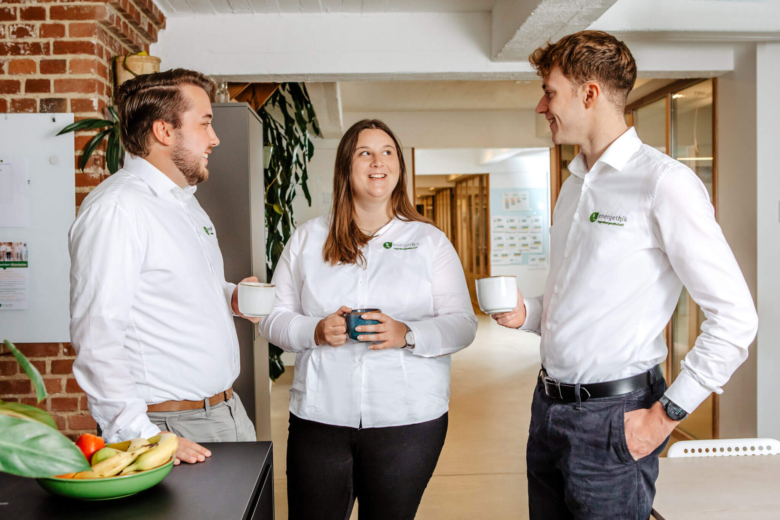3 Mitarbeiter von energethik unterhalten sich bei einer Tasse Kaffee