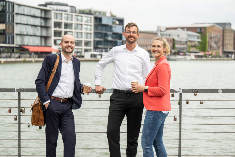 Drei Mitarbeiter auf einer Brücke von smartOPTIMO