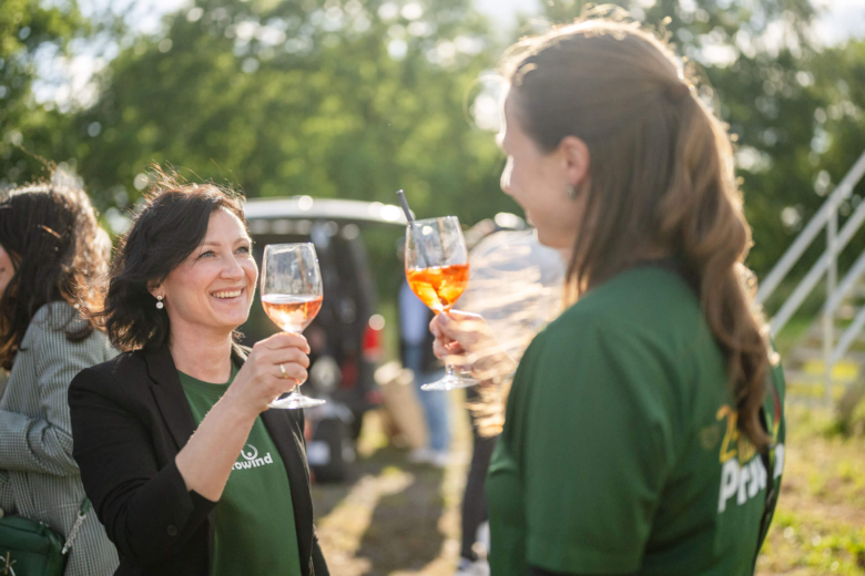 Zwei Personen stoßen mit einem Glas Wein an
