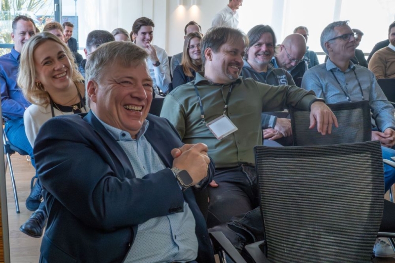 Gruppe von lachenden Personen bei einer Konferenz