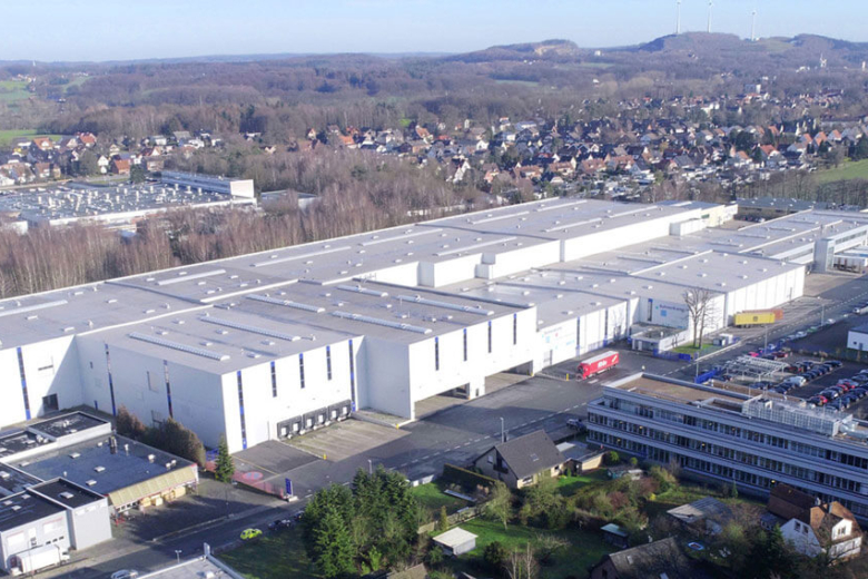 Luftaufnahme des weitläufigen Bohnenkamp-Unternehmensgeländes mit großen Lagerhallen und Bürogebäuden im Grünen.