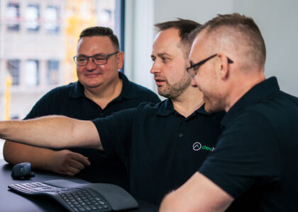 Drei Softwareentwickler von dev.house bei der gemeinsamen Code-Review am Bildschirm.