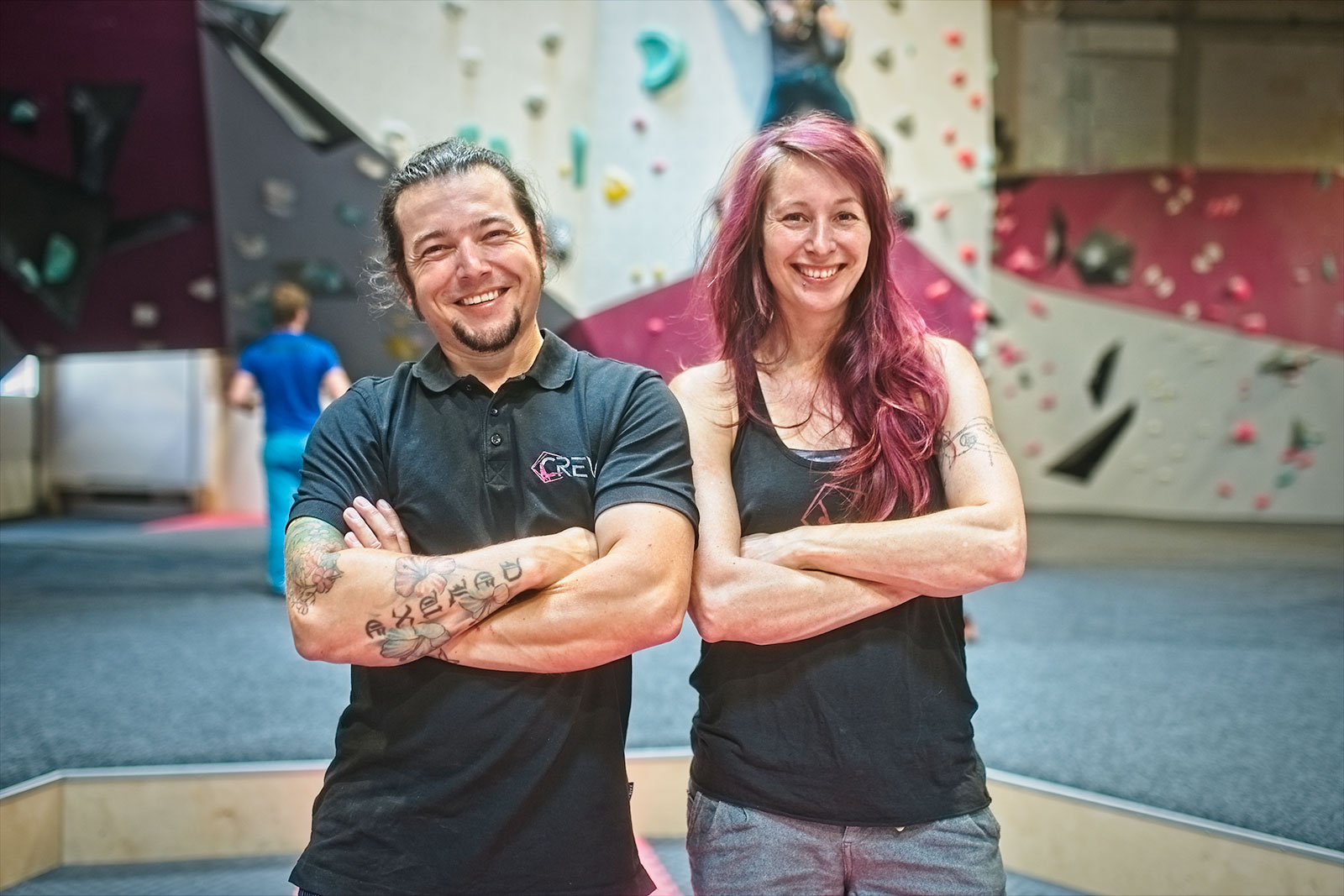 Ein Mann und eine Frau stehen mit verschränkten Armen lächelnd in einer Boulderdach-Halle.