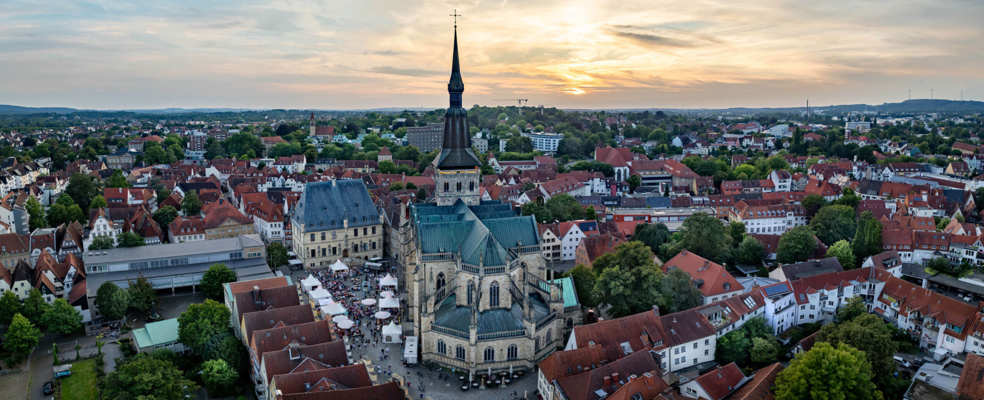 Luftaufnahme der Altstadt von Osnabrück mit der Marienkirche und dem Rathaus im Abendlicht.
