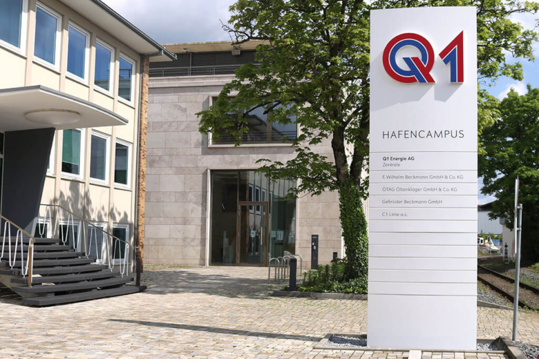 Weiße Stelen-Beschilderung Hafen-Campus mit Firmenlogos vor einem Treppenaufgang.