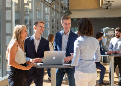 Vier Businessmenschen am Stehtisch