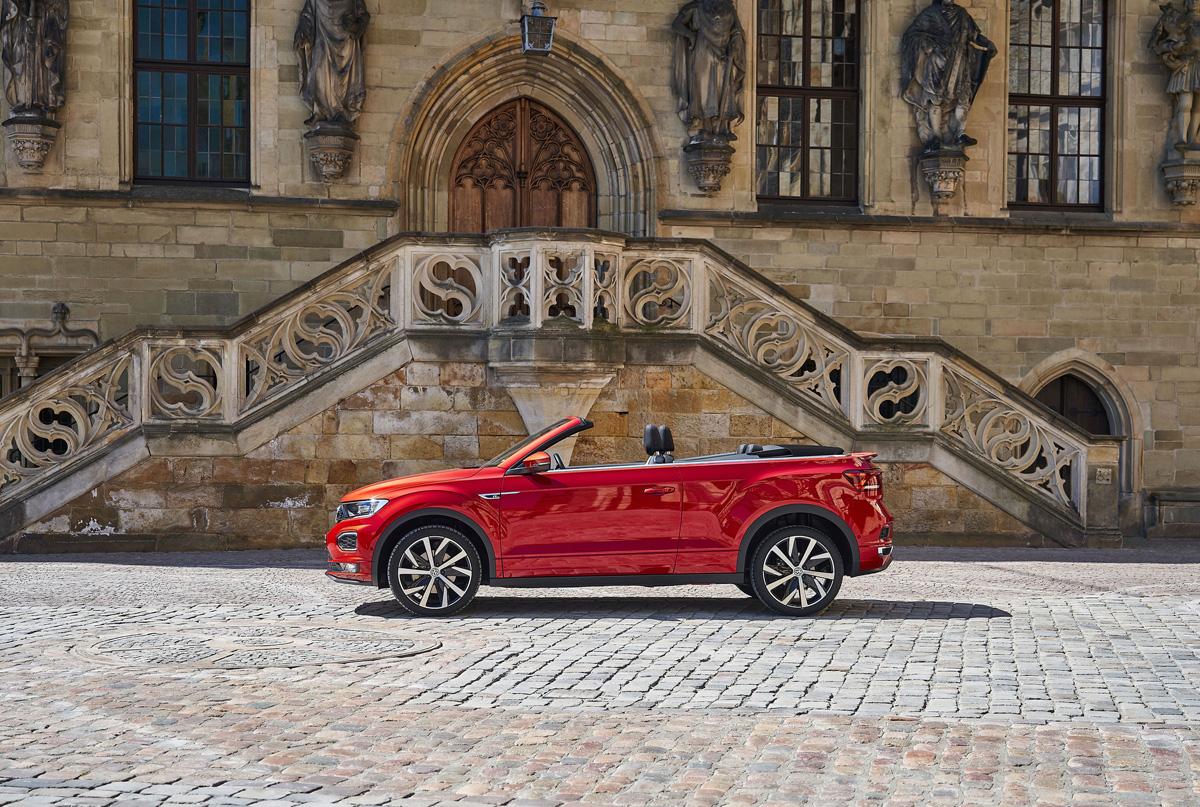 Rotes Volkswagen T-Roc Cabriolet steht auf Kopfsteinpflaster vor der historischen Fassade des historischen Rathauses Osnabrück.