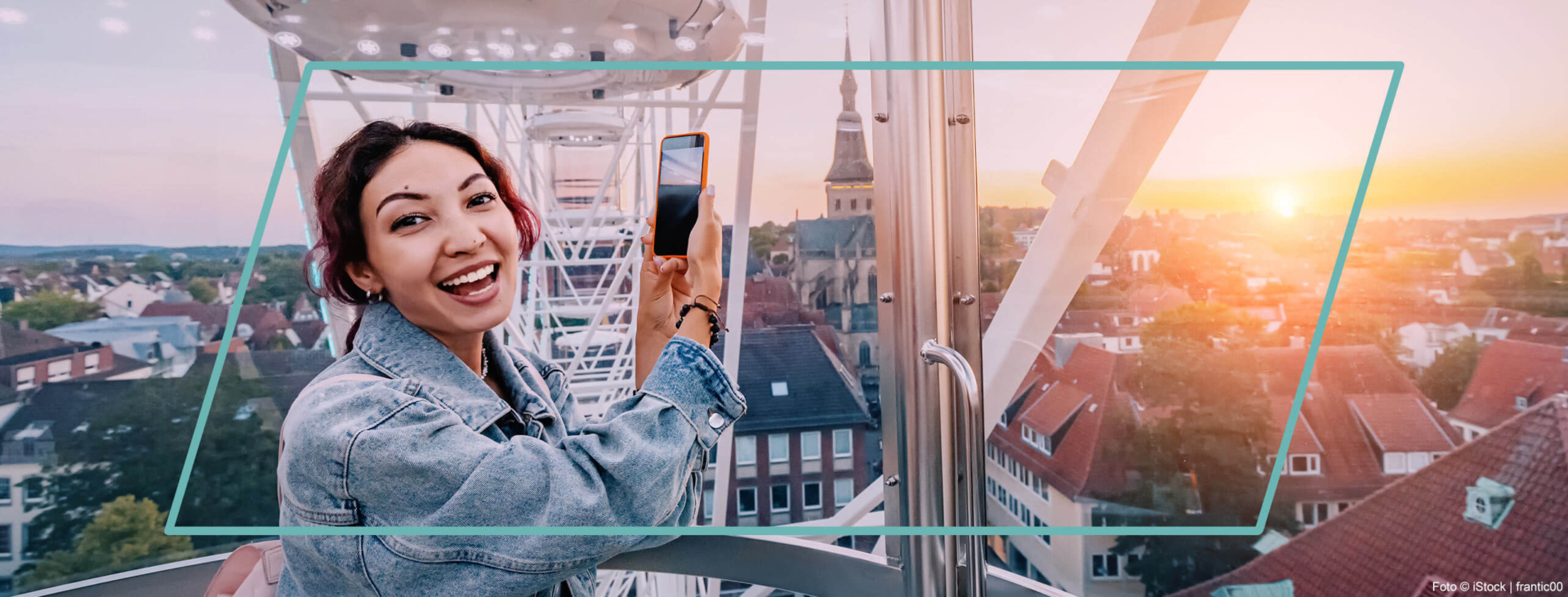 Eine Frau macht Fotos auf ihrem Handy während sie im Zentrum der Osnabrücker City auf einem Riesenrad fährt.